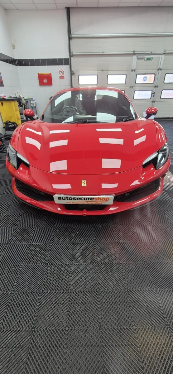 Red Ferrari in a workshop with Autosecureshop display plate